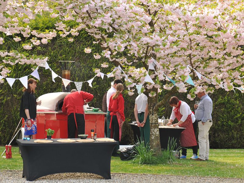 People being served wood fired pizza
